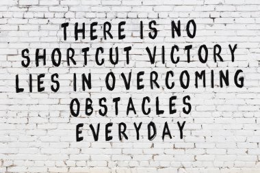 Üzerinde mantıklı alıntıların yazılı olduğu siyah boyanmış beyaz tuğla duvar.