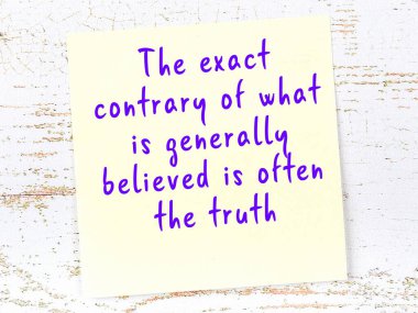 Tahta duvarda el yazısı motivasyon alıntısı olan sarı yapışkan not