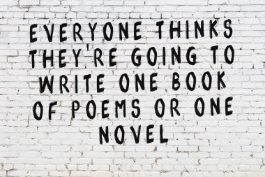 Üzerinde mantıklı alıntıların yazılı olduğu siyah boyanmış beyaz tuğla duvar.