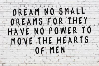 Beyaz tuğla duvar ve bilgece alıntıların yazılı olduğu siyah yazı.