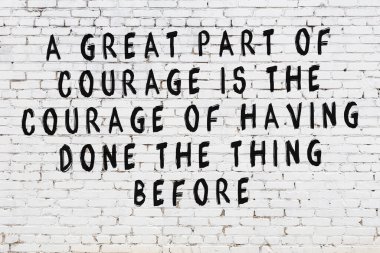 Beyaz tuğla duvar ve bilgece alıntıların yazılı olduğu siyah yazı.