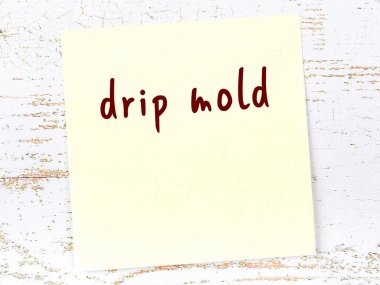 Damlama kalıbını hatırlatma anlayışı. Tahta duvarda üzerinde yazı olan sarı yapışkan kağıt.