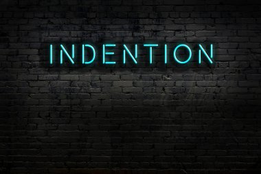 Duvara yazı kazınmış neon tabela. Gece görünümü