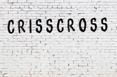 Üzerinde siyah boya bulunan beyaz tuğlalı bir duvar.