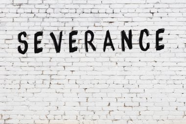 Beyaz tuğla duvarda siyah boyayla yazılmış tazminat..