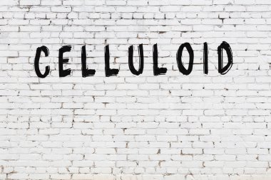 Siyah boyalı el yazısıyla yazılmış beyaz tuğlalı bir duvar.