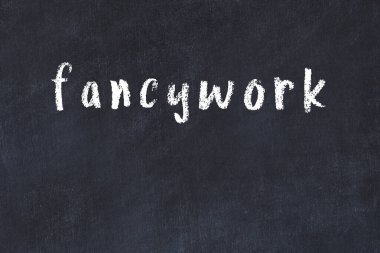 Tebeşir el yazısıyla yazılmış, siyah masanın üzerine süslü yazı.