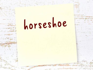 At nalı hakkında hatırlatma konsepti. Tahta duvarda üzerinde yazı olan sarı yapışkan kağıt.