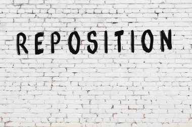 Siyah boyayla el yazısıyla yeniden yazılmış beyaz tuğla duvar.