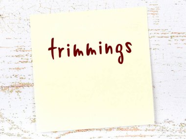 Tahta duvardaki sarı yapışkan notta el yazısı süslemeler var.