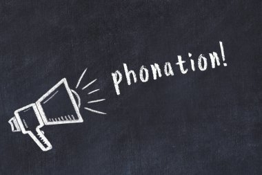 Hoparlörlerin tebeşir çizimi ve siyah masanın üzerine el yazısıyla yazılmış yazması.