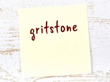 Kavrak taşını hatırlatma kavramı. Tahta duvarda üzerinde yazı olan sarı yapışkan kağıt.