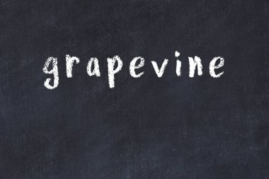 Tebeşir el yazısı siyah masanın üzerine asma asma.