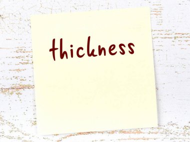 Tahta duvarda el yazısı kalınlığında sarı yapışkan bir not var.