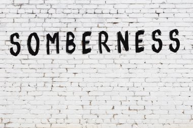 Beyaz tuğla duvara siyah boya ile yazılmış bir yazıt uysallığı..