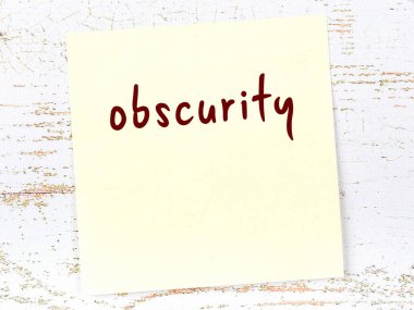 Bilinmezlik hakkında hatırlatma kavramı. Tahta duvarda üzerinde yazı olan sarı yapışkan kağıt.