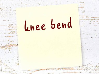 Tahta duvarda, el yazısıyla yazılmış bir not var. Diz çök.