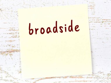 Tahta duvardaki sarı yapışkan notta elle yazılmış borda yazı var.