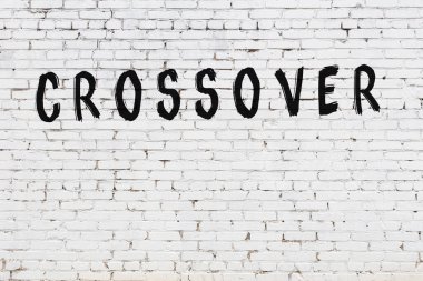 Beyaz tuğlalı duvara siyah boya ile yazılmış bir yazı geçişi.