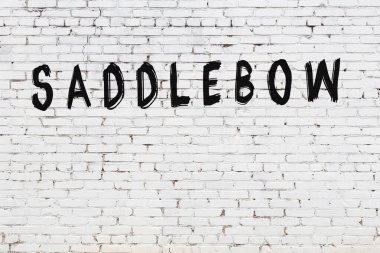 Yazılı beyaz tuğla duvar, siyah boyalı el yazısı.