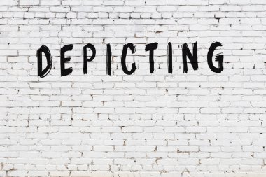 Üzerinde siyah boyayla el yazısı olan beyaz tuğla bir duvar.