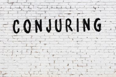 Beyaz tuğla duvara siyah boya ile yazılmış bir büyü..