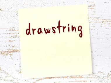 Tahta duvarda el yazısıyla çizilmiş sarı yapışkan bir not.