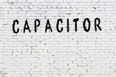 Beyaz tuğla duvara siyah boya ile yazılmış yazıt kapasitörü.