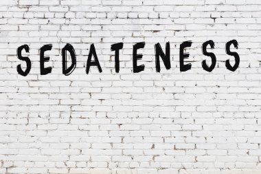 Siyah boyalı el yazısıyla yazılı beyaz tuğla duvar.