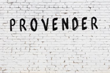 Üzerinde yazı olan beyaz tuğla duvar. Siyah boyayla el yazısı.