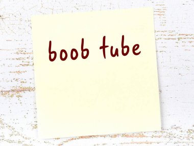 Tahta duvarda el yazısıyla yazılmış göğüs tüpü olan sarı yapışkan bir not.