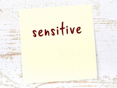 Hassas hakkında hatırlatma kavramı. Tahta duvarda üzerinde yazı olan sarı yapışkan kağıt.