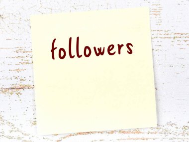 Tahta duvarda sarı yapışkan bir not ve el yazısıyla yazılmış müritleri var.