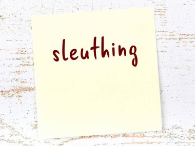 Hafiyelik hakkında bir hatırlatma. Tahta duvarda üzerinde yazı olan sarı yapışkan kağıt.