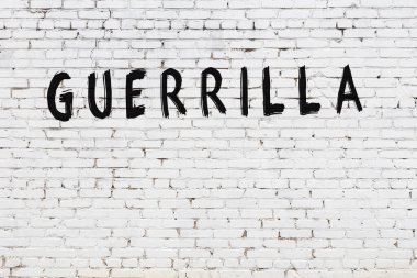 Yazı gerillası, beyaz tuğla duvara siyah boya ile yazılmış..