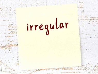 Düzensizliği hatırlatma kavramı. Tahta duvarda üzerinde yazı olan sarı yapışkan kağıt.