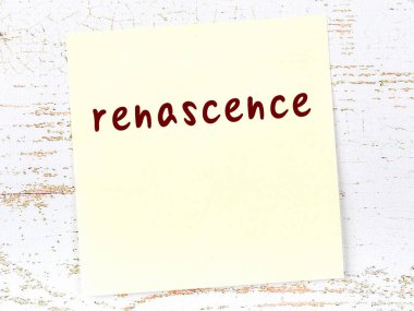 Tahta duvarda el yazısıyla yazılmış sarı yapışkan bir not var.