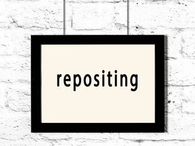 Beyaz tuğla duvara asılmış siyah ahşap çerçeve. 