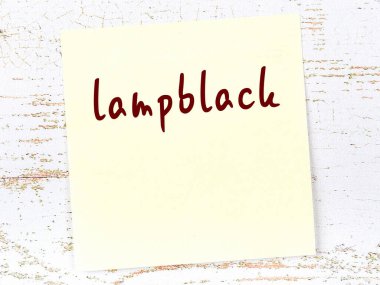 Tahta duvardaki sarı yapışkan notta el yazısıyla yazılmış lamba siyahı var.