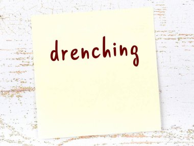 Ahşap duvarda, el yazısıyla yazılmış, sırılsıklam olmuş sarı yapışkan bir not.