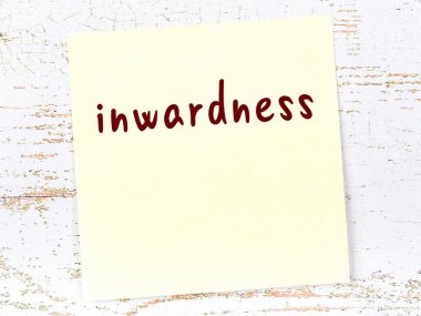 Ahşap duvarda, içinde el yazısı olan sarı yapışkan bir not.