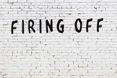 Yazılı beyaz tuğla duvar, siyah boyayla el yazısıyla ateş edilmiş.