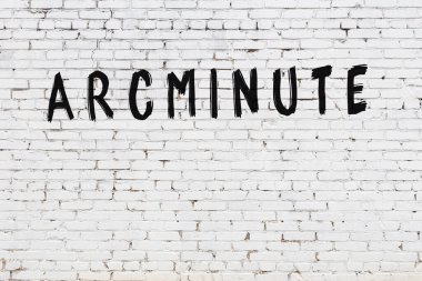 Üzerinde siyah boya bulunan beyaz tuğla bir duvar.