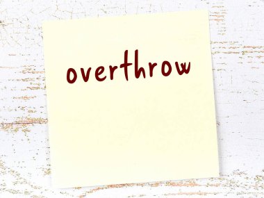 Tahta duvarda el yazısıyla yazılmış sarı yapışkan bir not var.