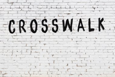 Üzerinde siyah boya bulunan beyaz tuğlalı bir duvar.