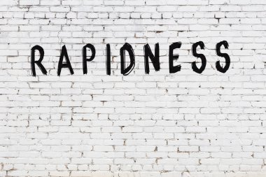 Siyah boyayla el yazısıyla yazılmış beyaz tuğlalı bir duvar.