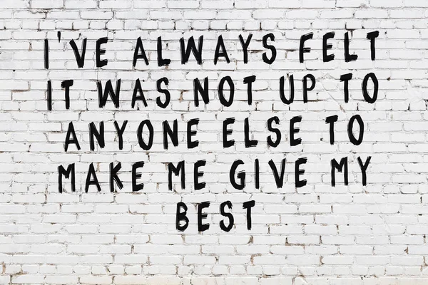 Beyaz tuğla duvar ve bilgece alıntıların yazılı olduğu siyah yazı.