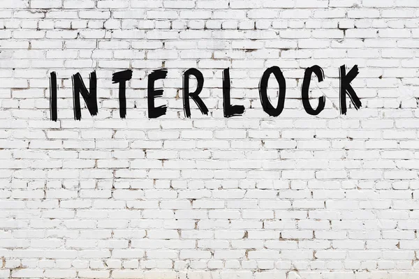 Vit Tegelvägg Med Inskription Interlock Handskriven Med Svart Färg — Stockfoto