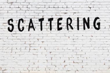 Üzerinde yazı olan beyaz tuğla duvar. Elle yazılmış siyah boya.