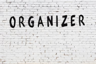 Beyaz tuğla duvara siyah boya ile yazılmış bir yazıt düzenleyici.